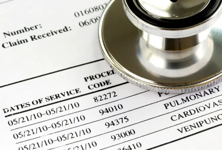 A close up of a medical bill with a stethoscope on top of it