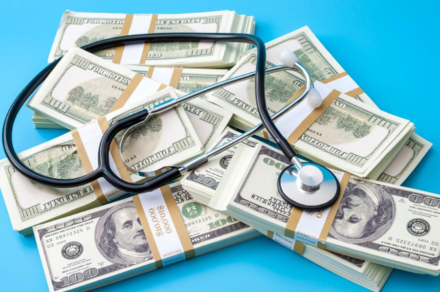 A stethoscope lying across a pile of money