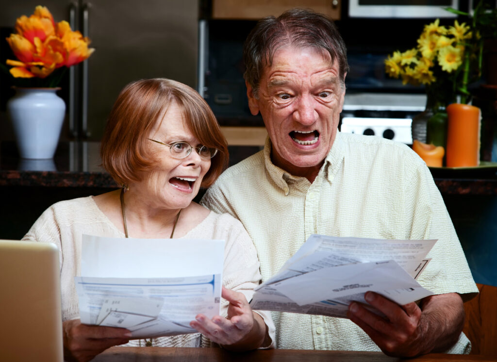 Picture of a shocked couple looking over medical bills