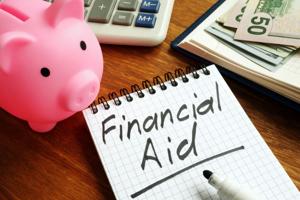 Financial aid sign with money and piggy bank to help purchase qualified health plans.