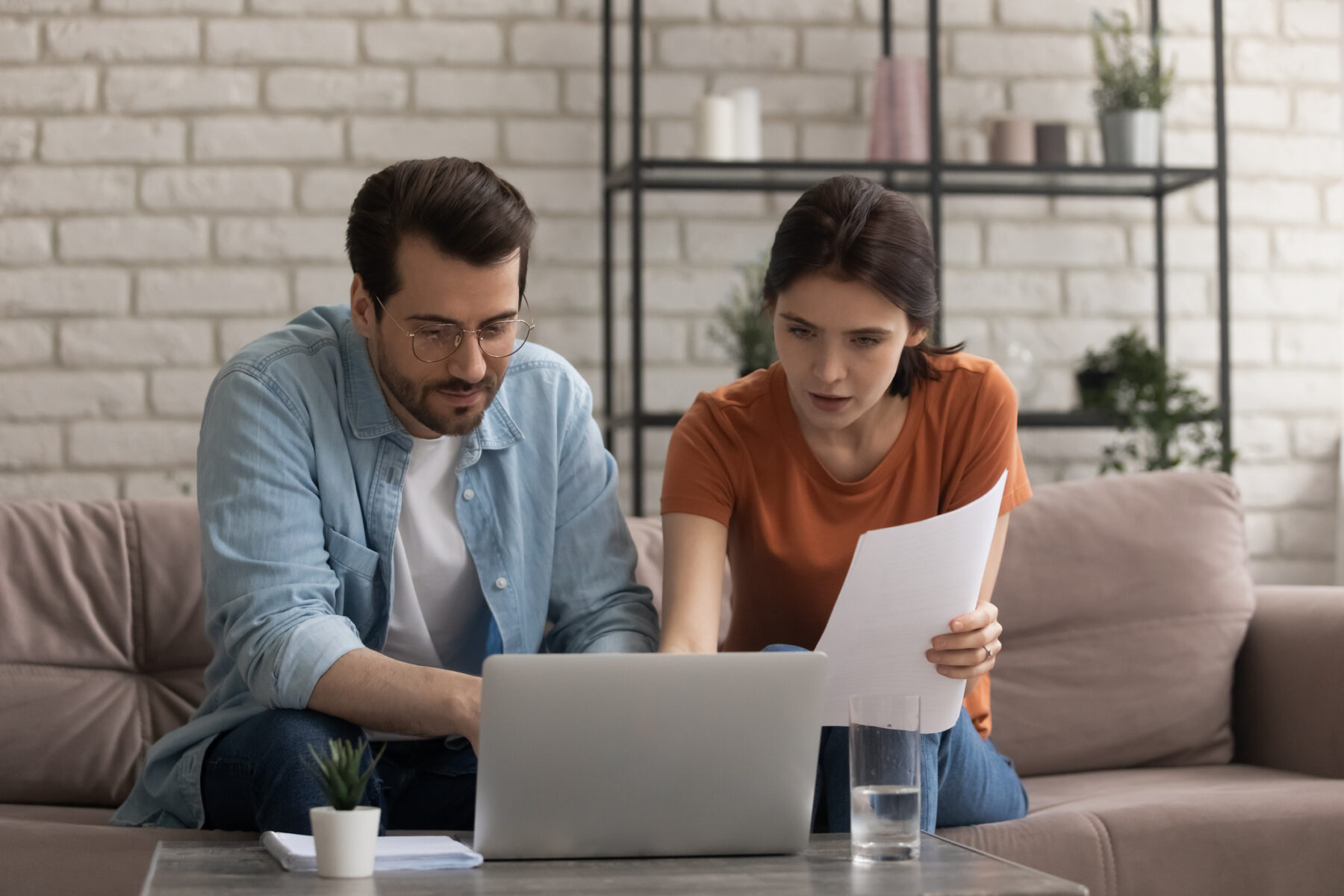 Focused young married couple comparing estimates for planned healthcare services.